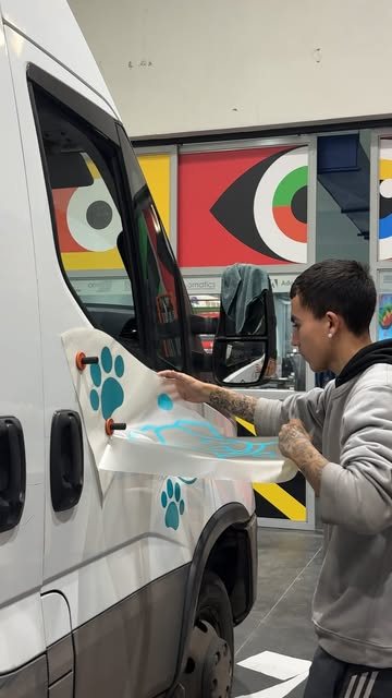 Técnico instalando vinilo de precisión sobre una puerta de vehículo